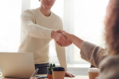 a person shaking hands in a business meeting